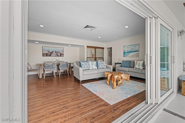 living room with hardwood / wood-style floors and crown molding