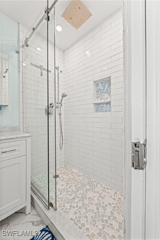 bathroom featuring vanity and a shower with shower door