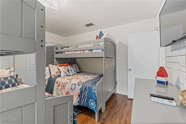 bedroom featuring a textured ceiling and hardwood / wood-style flooring