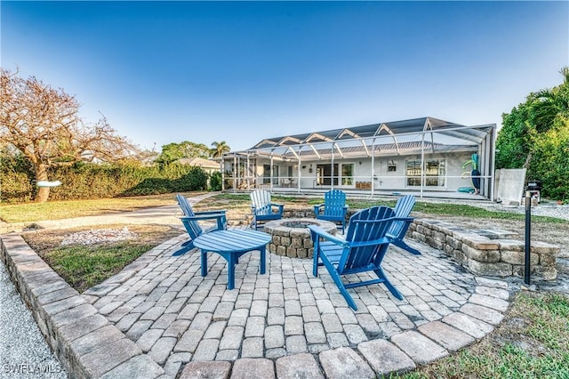 view of patio / terrace with a fire pit and a lanai