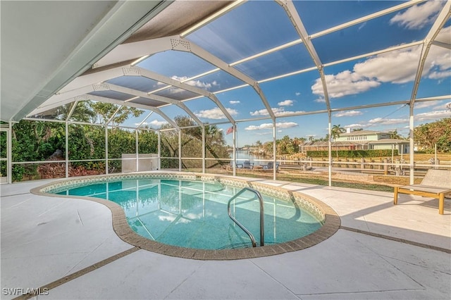 view of swimming pool featuring glass enclosure and a patio