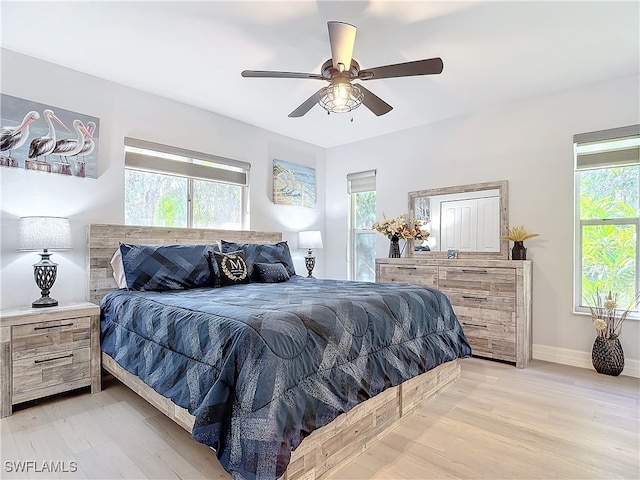 bedroom featuring light wood-style floors, ceiling fan, and baseboards