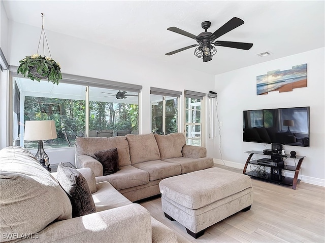 living room with a ceiling fan, light wood-type flooring, visible vents, and baseboards