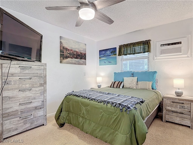 bedroom featuring light colored carpet, a wall unit AC, a textured ceiling, and ceiling fan