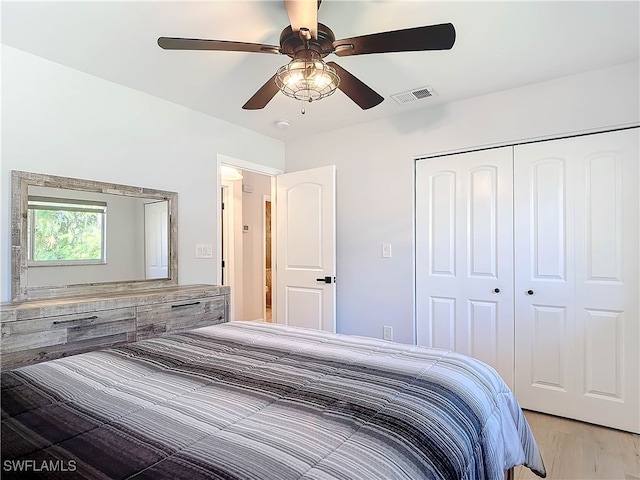 bedroom with a closet, visible vents, ceiling fan, and light wood finished floors