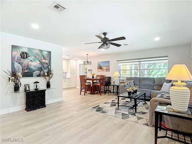 living room with light hardwood / wood-style flooring and ceiling fan