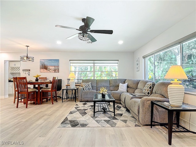 living area with light wood finished floors, ceiling fan, baseboards, and recessed lighting