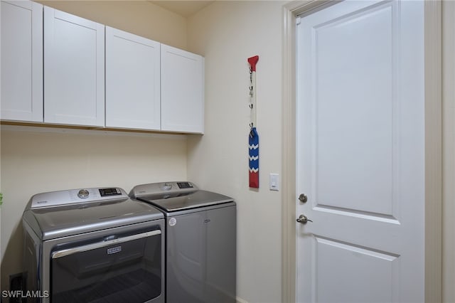 washroom with cabinets and washer and clothes dryer