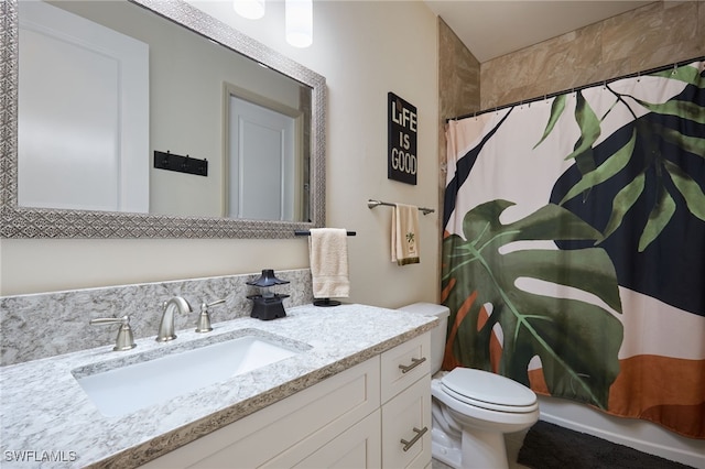 bathroom with vanity, curtained shower, and toilet