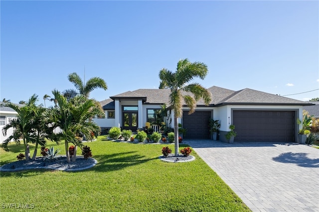 view of front of home with a front yard and a garage