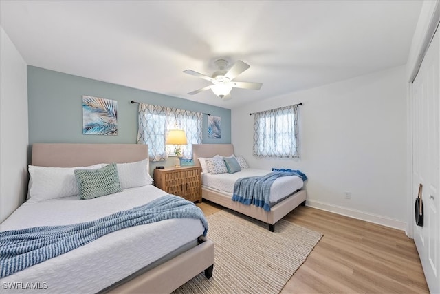 bedroom with a closet, ceiling fan, and light hardwood / wood-style flooring