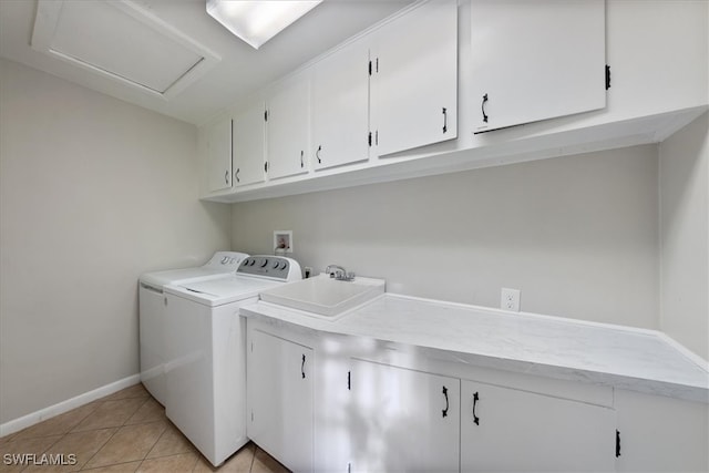 laundry room featuring light tile patterned flooring, cabinets, independent washer and dryer, and sink