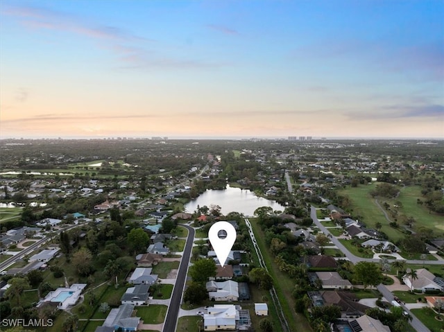 aerial view at dusk featuring a water view