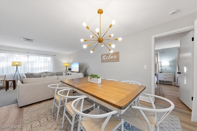 dining room with a notable chandelier and light wood-type flooring