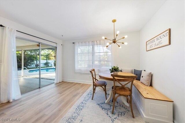 dining area with an inviting chandelier and light hardwood / wood-style flooring