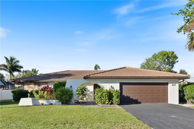 mediterranean / spanish-style house featuring a front lawn and a garage