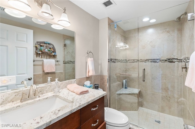 bathroom featuring toilet, vanity, and walk in shower