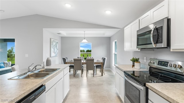 kitchen featuring appliances with stainless steel finishes, white cabinetry, hanging light fixtures, and sink