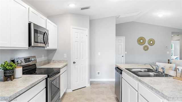 kitchen featuring sink, white cabinets, lofted ceiling, and appliances with stainless steel finishes