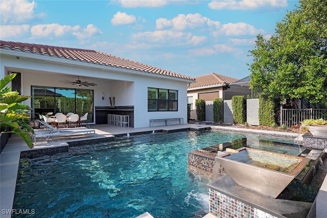 view of pool featuring a patio area, ceiling fan, pool water feature, area for grilling, and a bar