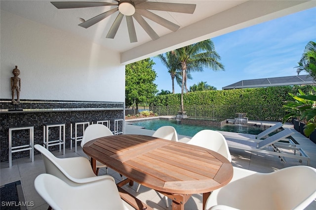 view of patio / terrace with ceiling fan, a fenced in pool, and exterior bar