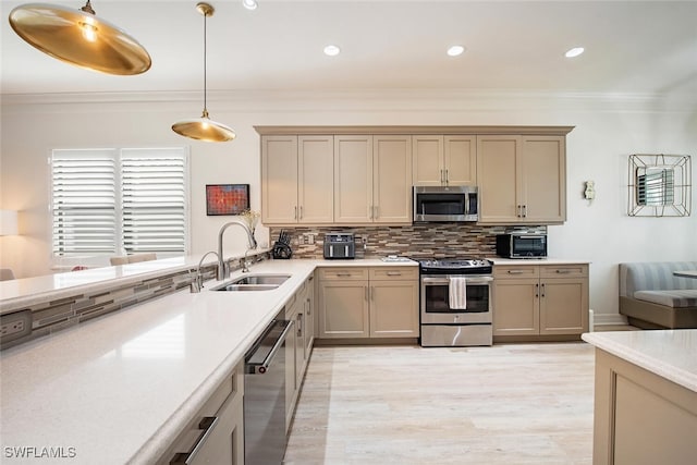 kitchen featuring light wood-type flooring, tasteful backsplash, stainless steel appliances, sink, and pendant lighting