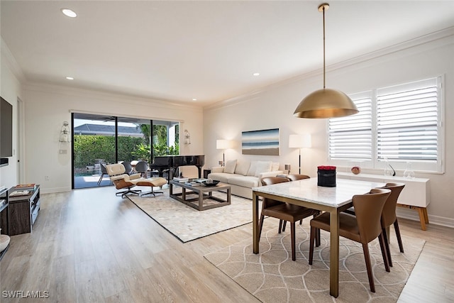 dining space featuring crown molding and light wood-type flooring