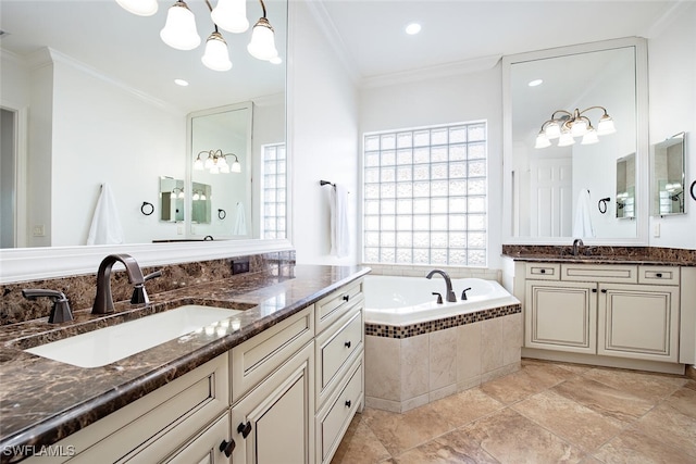 bathroom with a notable chandelier, vanity, ornamental molding, and tiled bath