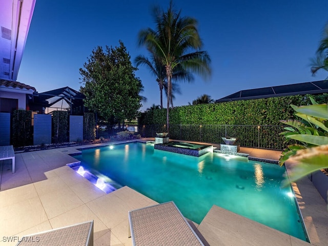 pool at dusk featuring an in ground hot tub, pool water feature, and a patio