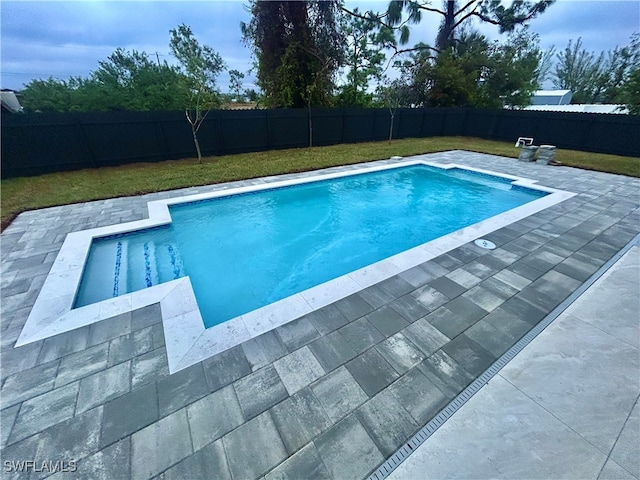 view of swimming pool featuring a yard and a patio