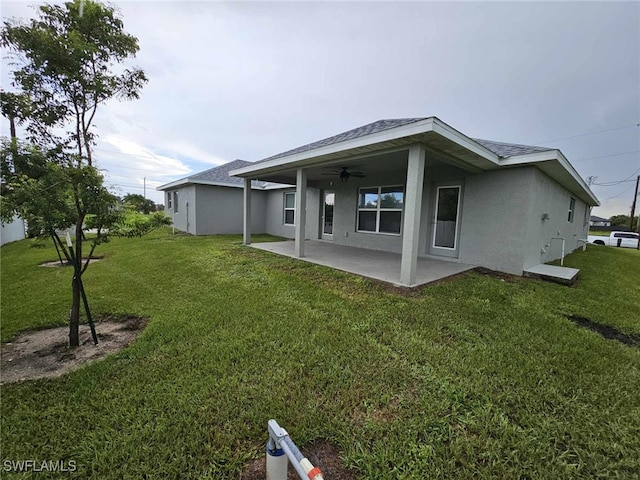 rear view of house featuring ceiling fan, a patio area, and a yard