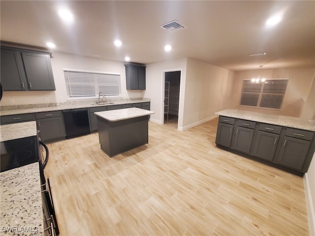 kitchen featuring light stone countertops, light wood-type flooring, sink, dishwasher, and a center island