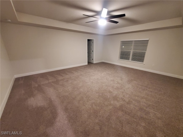 spare room with ceiling fan and dark carpet