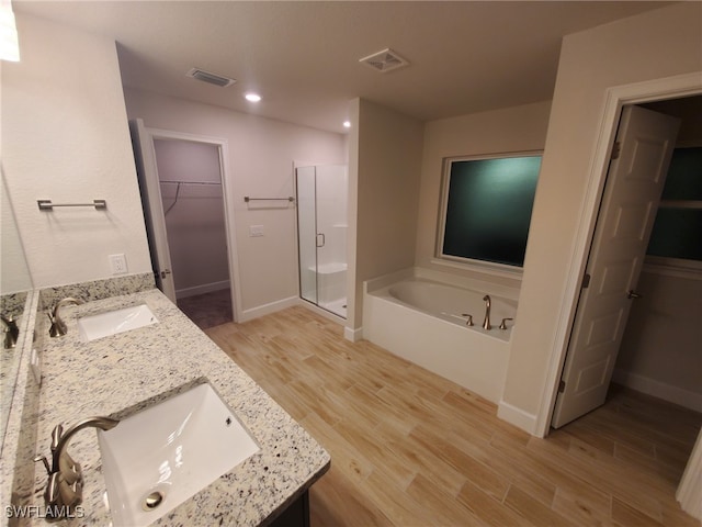 bathroom featuring vanity, wood-type flooring, and shower with separate bathtub