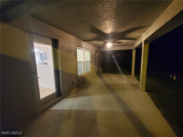 corridor with a textured ceiling and concrete floors