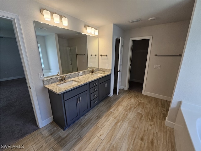 bathroom with hardwood / wood-style flooring, vanity, and separate shower and tub