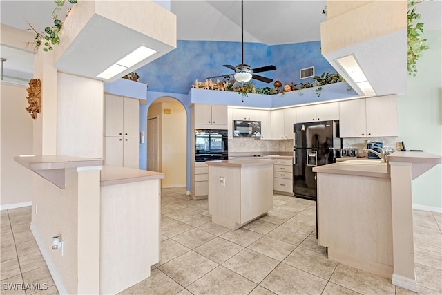 kitchen with black appliances, light tile patterned floors, kitchen peninsula, and high vaulted ceiling