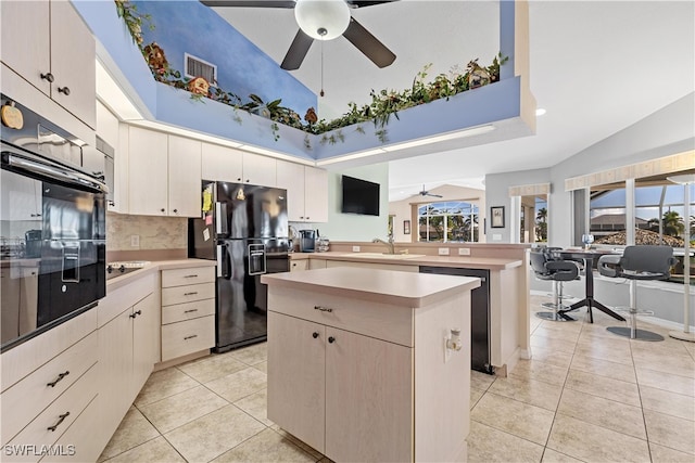 kitchen with a center island, vaulted ceiling, a wealth of natural light, and black appliances