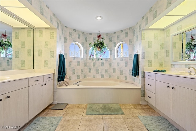 bathroom featuring tile patterned flooring, vanity, and a tub to relax in