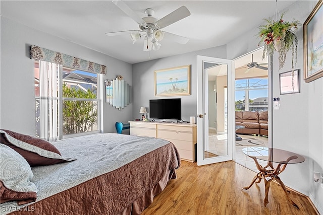 bedroom featuring light wood-type flooring, multiple windows, and ceiling fan