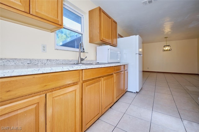 kitchen featuring light stone countertops, white appliances, sink, hanging light fixtures, and light tile patterned flooring