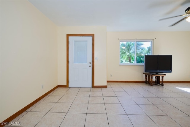 tiled spare room featuring ceiling fan