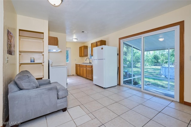 tiled living room with sink and washer / dryer