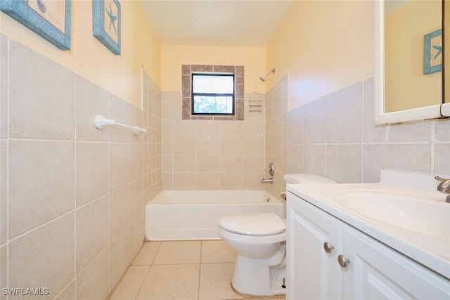 full bathroom with vanity, tile patterned floors, tiled shower / bath combo, toilet, and tile walls