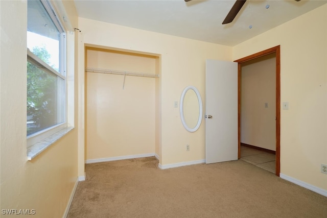 unfurnished bedroom with ceiling fan, a closet, and light colored carpet