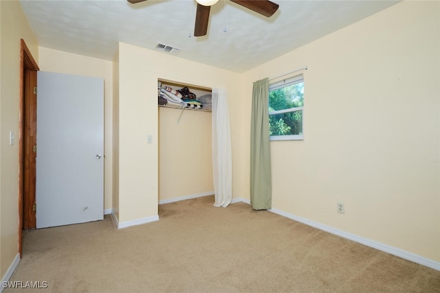 unfurnished bedroom featuring ceiling fan, a closet, and light carpet