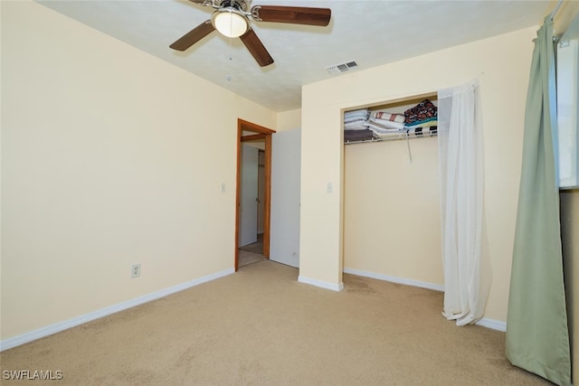 unfurnished bedroom with light colored carpet, a closet, and ceiling fan