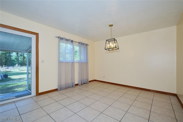 tiled empty room featuring a notable chandelier