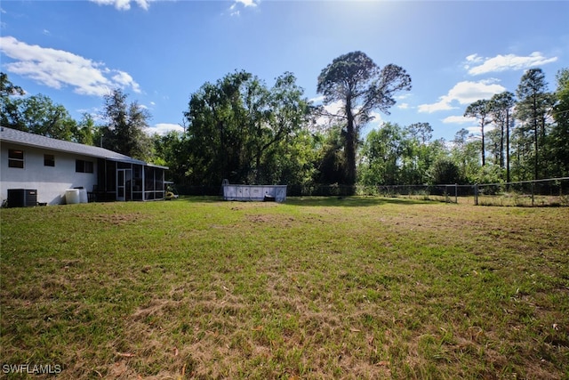 view of yard with central AC unit and a swimming pool