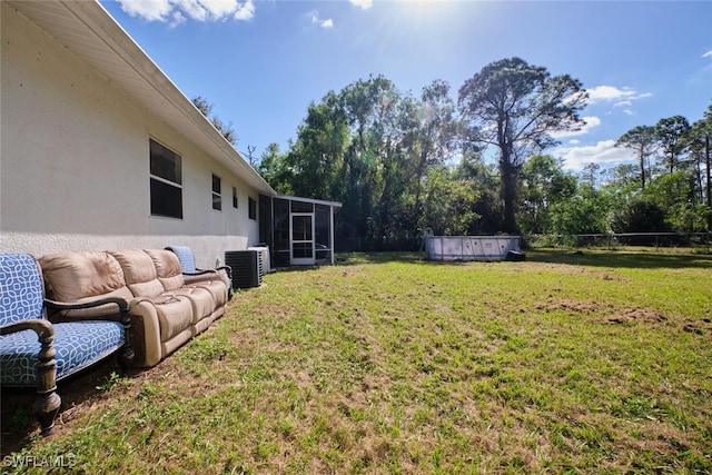 view of yard featuring a sunroom and central AC unit